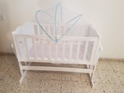 עריסה נצמדת למיטה , מתנדנדת עם כילה נגד יתושים .